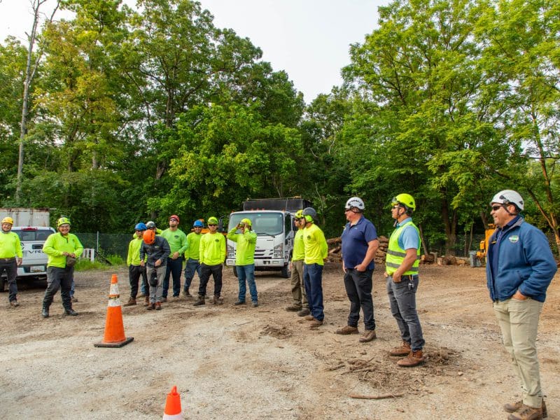 Construction workers gathered outdoors for a safety briefing.